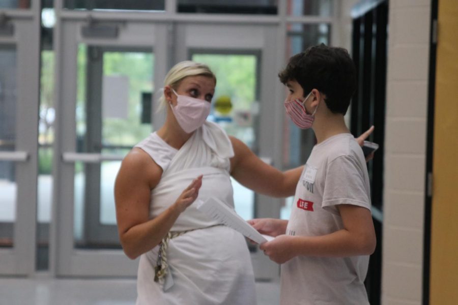 Assisting a freshman in reading his schedule, math teacher Jessica DeWild explains how to get to his class. 