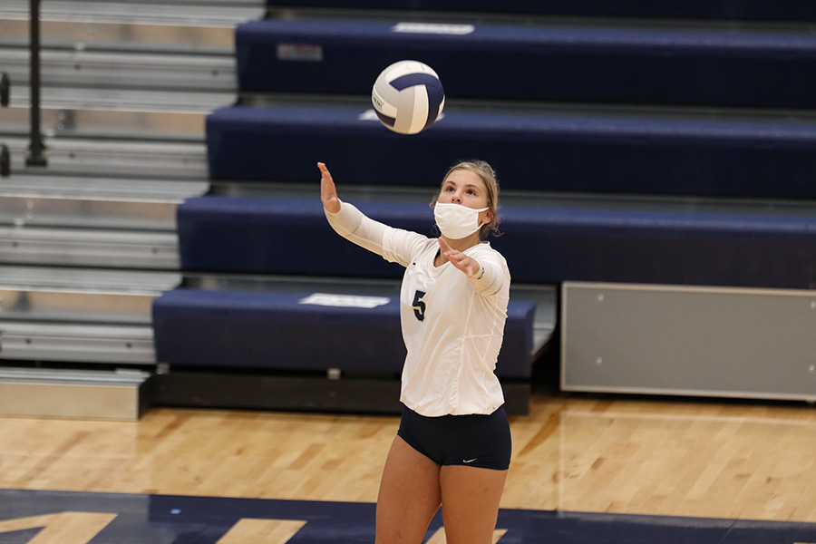 Tossing the ball in front of her, senior Anna Judd begins to serve to the other team. The Mill Valley volleyball team won the first three sets against Leavenworth Tuesday, Sept. 1 in the new gym, leaving the final score 3-0.