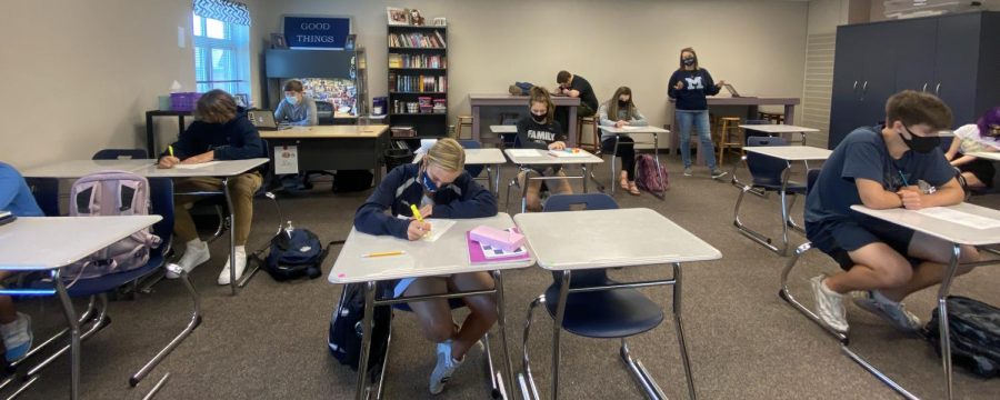 English teacher Ashley Agres students work on classwork. My desks are usually set up in tables and now the kids are all sitting by themselves and my classroom is so quiet – I don’t like quiet, Agre said. I like collaborating and working together noise.