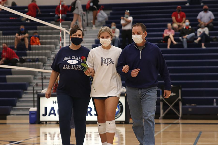 Walking with her parents, senior Anna Judd is recognized for senior night. The girls volleyball team won a triangular against Lawrence High School and Lawrence Free State on Tuesday, Sept. 29, beating Lawrence in 2 sets, and Lawrence Free State in 3 sets. 