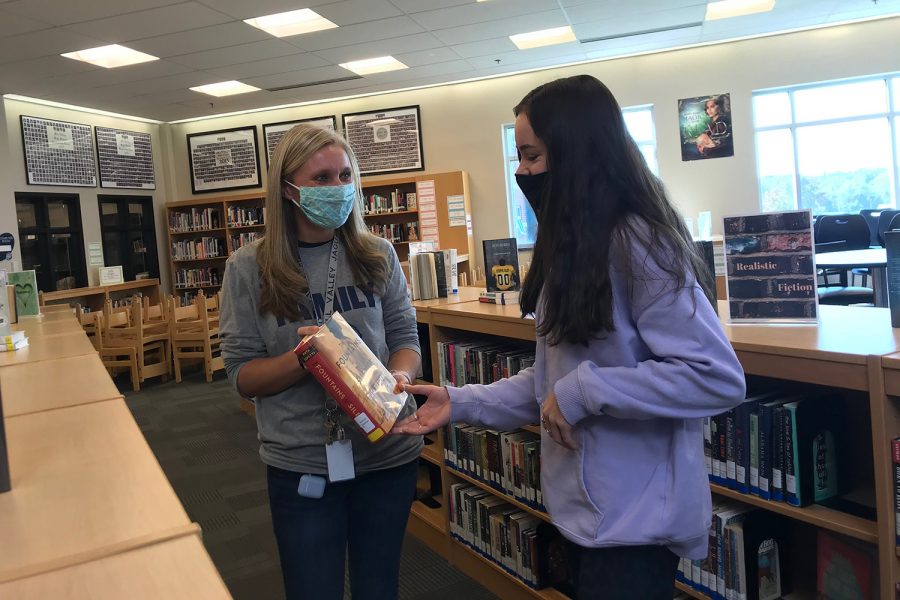 Ashley Bennett shares book recommendations and Book Club information with a member of her club. 