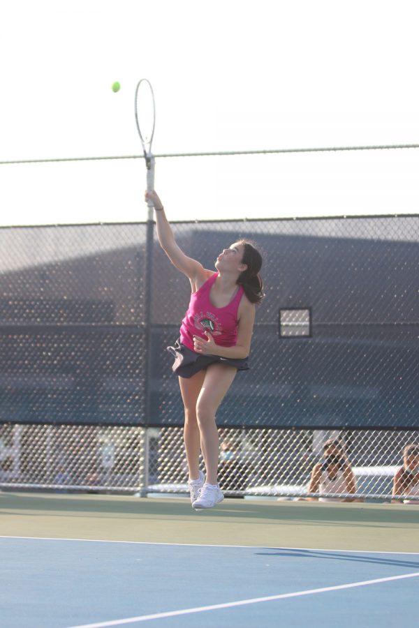 Serving to her opponent, junior Eden Schanker makes contact with the ball.
