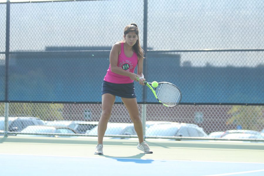 Focusing, senior Isabella Loya prepares to hit a backhand to her opponent. 
