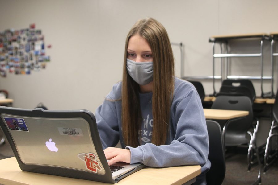 Sitting in an empty classroom, freshman Abby Wolff works on her canvas assignment on Monday, Oct. 19.