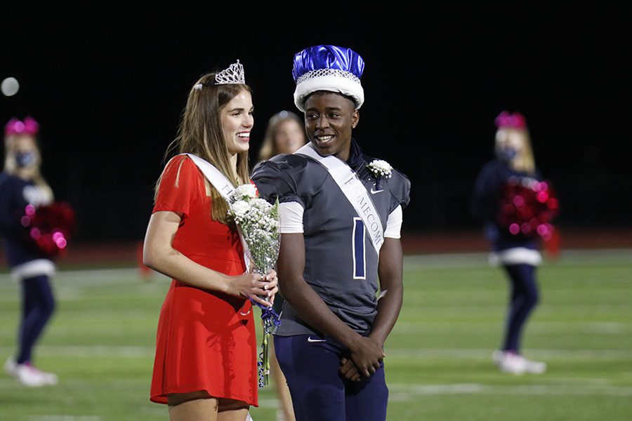 Posing for the cameras, homecoming king Quin Wittenauer smiles at homecoming queen Ellie Boone. 
