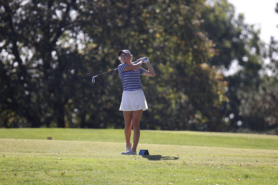 Watching the ball, junior Charley Strahm follows through on her swing. 