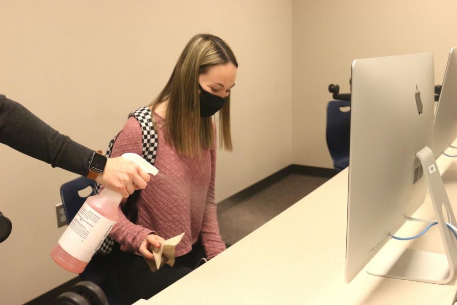 Before leaving class, senior Ella Greenup wipes down her desk with a paper towel and disinfectant Thursday, Oct 1. 