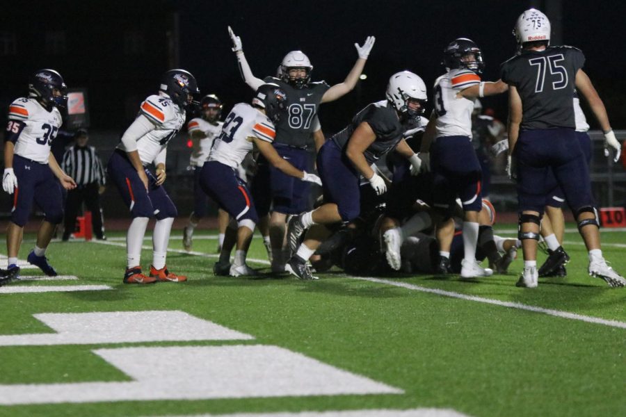 Hands in air to represent a touchdown, wide receiver Jared Napoli stands next to the pile of football players to show the referee that they had made it into the end zone.