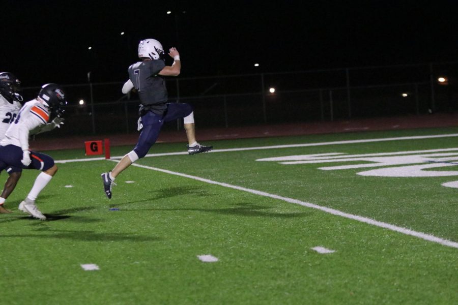 While scoring a touchdown, quarterback Cooper Marsh jumps into the air.