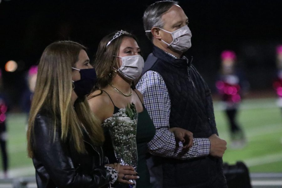 Senior Katherine Weigel walks with her parents to meet up with her homecoming partner.