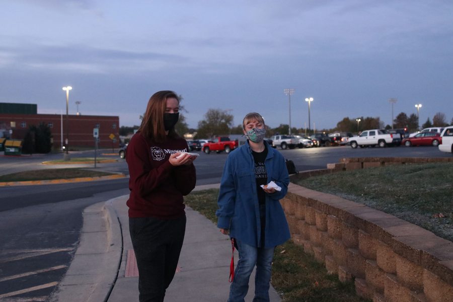 Seniors Sydney Knapp (right) and Kennedy Eyberg (left) eat their donuts together while social distancing. 
