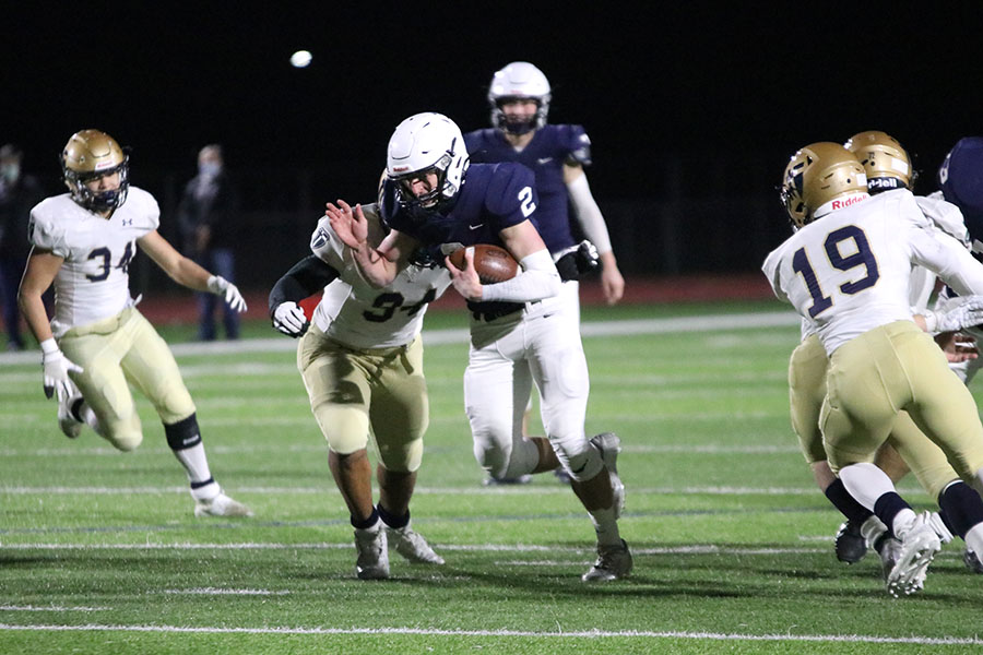 With the ball in his hands, sophomore Hayden Jay sprints down the field to avoid being tackled. 