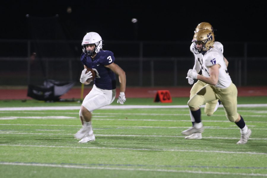 Focusing, senior Jacob Hartman tries to gain a few more yards.
