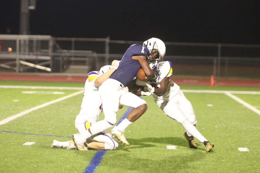 Pushing through, senior Quin Wittenauer works hard to avoid getting tackled by the other team’s defense.
