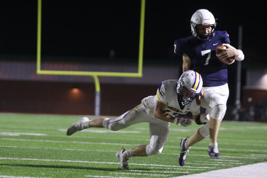 Running the ball, senior Cooper Marsh avoids being tackled as he steps out of bounds.
