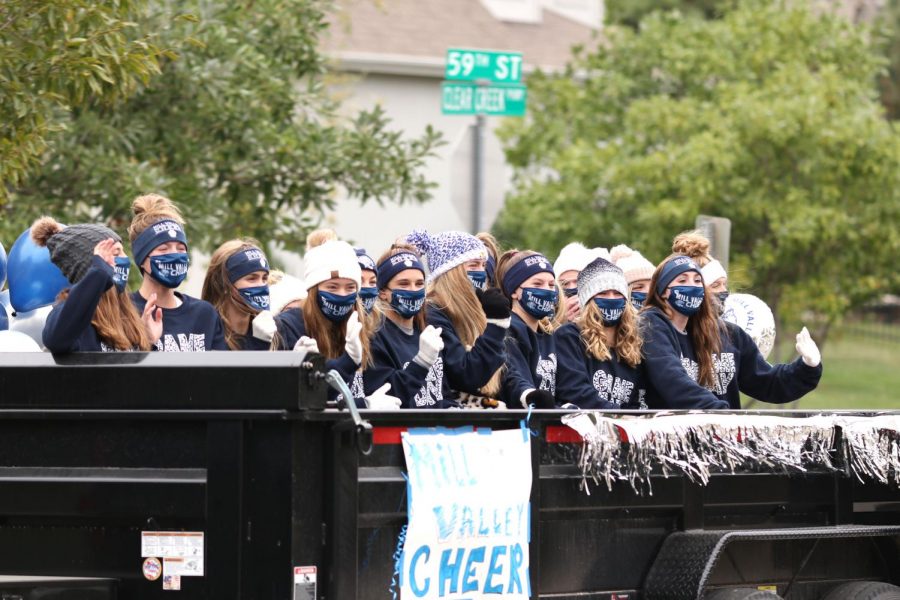 The school cheerleaders wave to a crowd of on-lookers in Clear Creek during the senior organized homecoming parade on Sunday, Oct. 18.