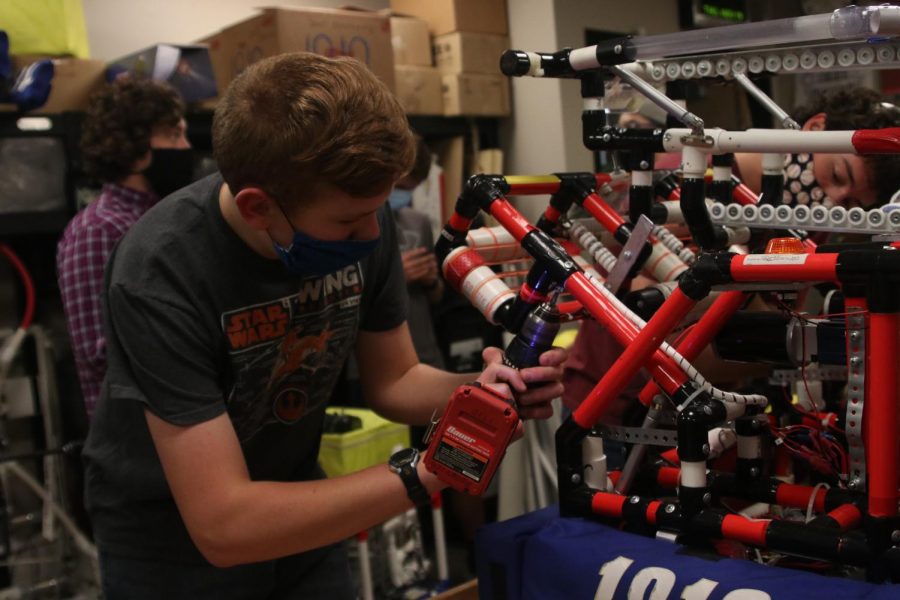De Soto freshman and new robotics recruit  Moses Morton uses a drill on last years robot, the Red Skeleton Thursday, Nov. 19