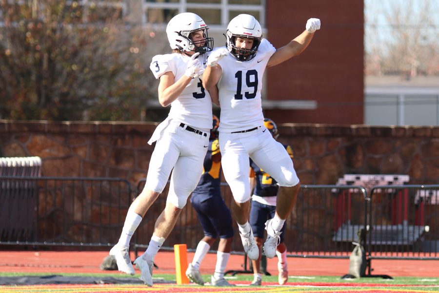 In celebration, wide receivers Jacob Hartman and Ty Reishus jump up to shoulder bump after a touchdown.
