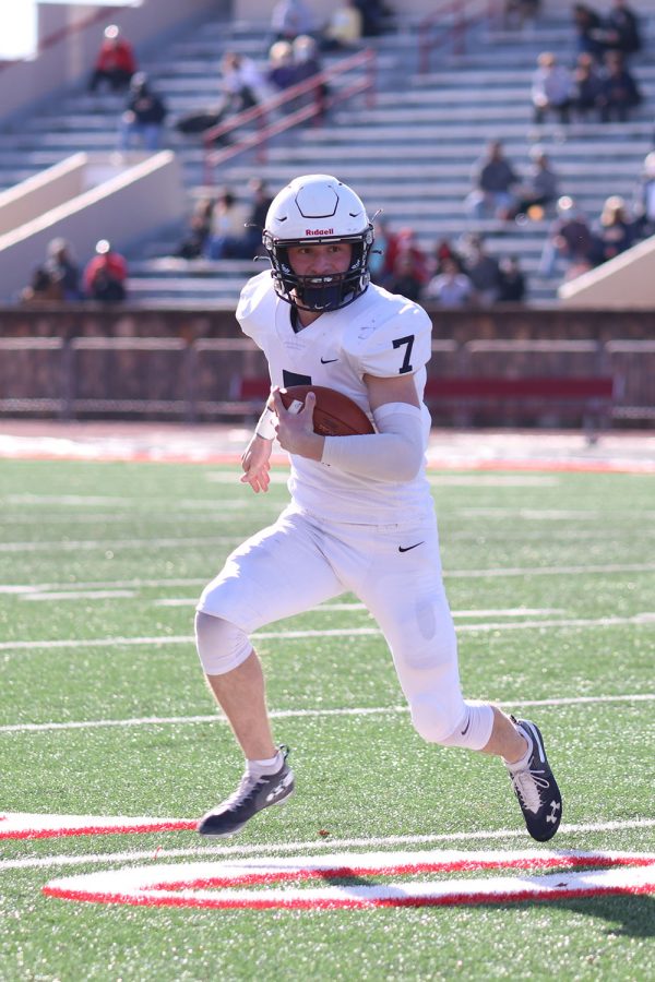 In order to carry, quarterback Cooper Marsh holds onto the ball and advances it.
