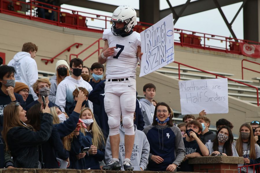 Holding a sign, quarterback Cooper Marsh poses for a photo. 
