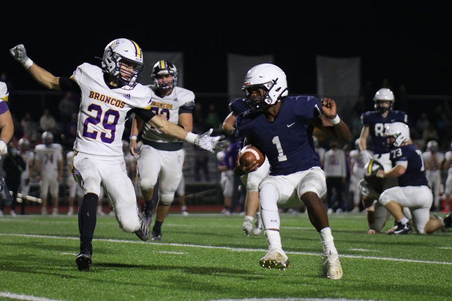 Running up the field, running back Quin Wittenauer tries to fake the other player and run past him.