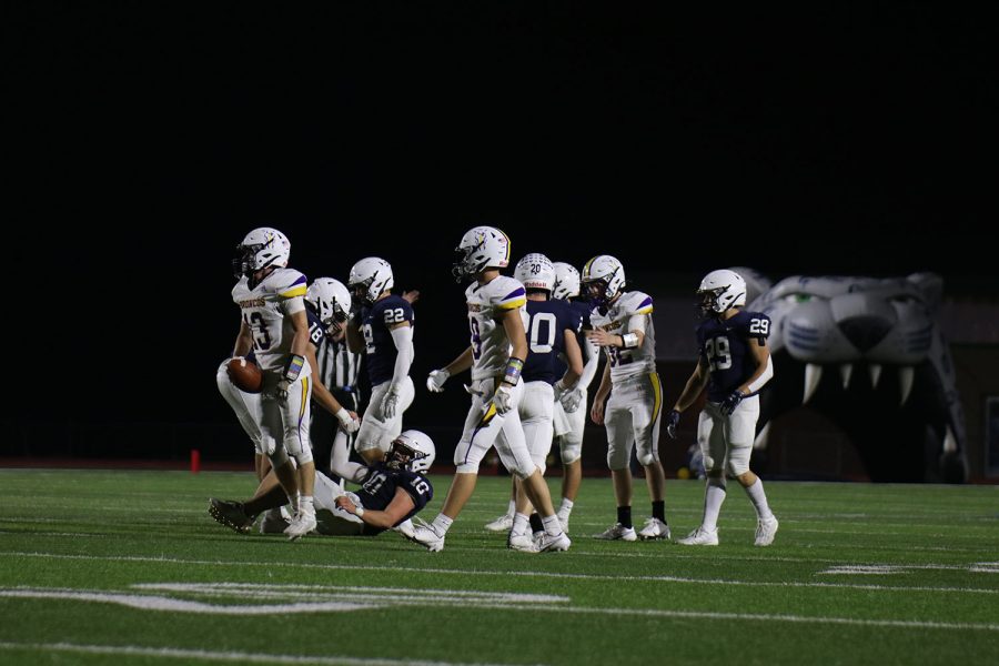 After finishing a play, defensive linemen Pete Janssen helps up linebacker Kolten Jegen.