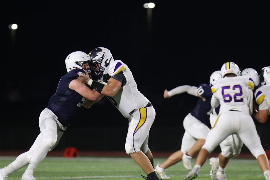 Trying to block, defensive lineman Cody Moore grabs onto the other players shoulders.