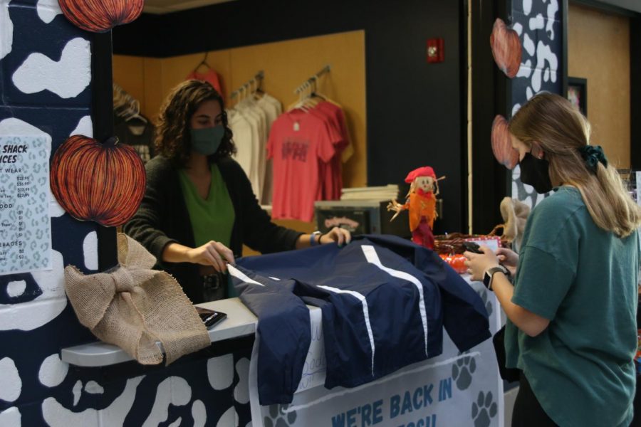 Nicole helps a student pick out a new jacket, so the student does not get the wrong size. 