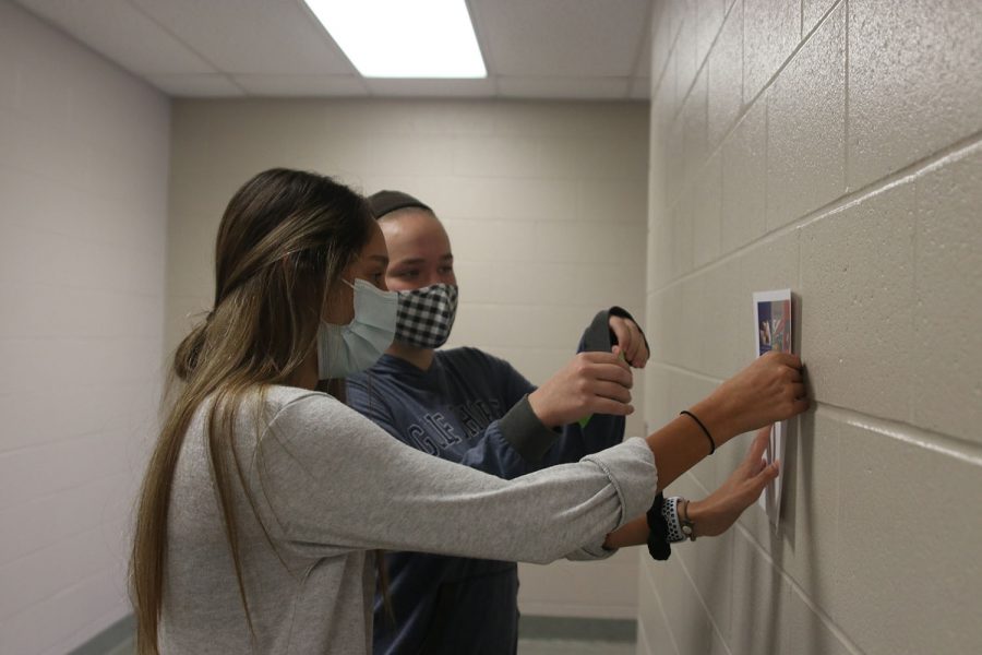 Taping a poster to the wall, juniors Carly Knight and Vania Arora kick off French week Wednesday, Nov. 3.  