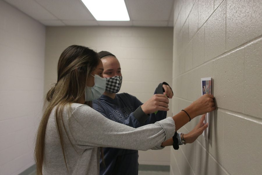 Taping+a+poster+to+the+wall%2C+juniors+Carly+Knight+and+Vania+Arora+kick+off+French+week+Wednesday%2C+Nov.+3.++