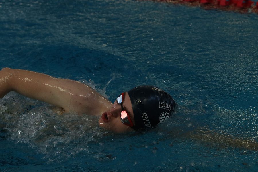 Taking a breath, junior Derek Long swims freestyle at the Lansing Relays Saturday, Dec. 5. 
