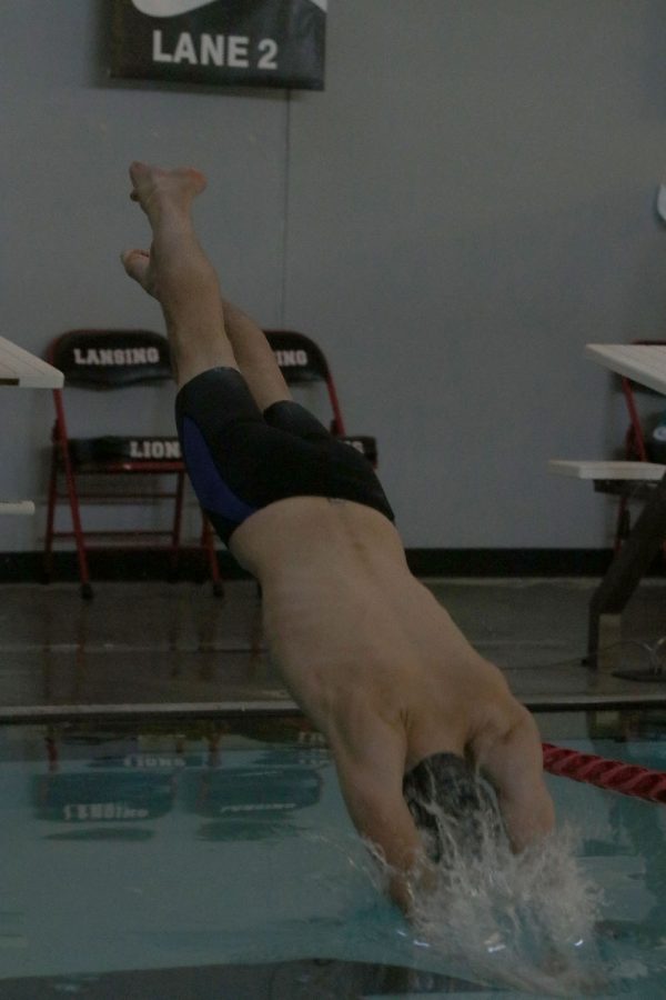 Mid-air, junior Brendan Akehurst dives off the block as the first swimmer of his relay Saturday, Dec. 5. 