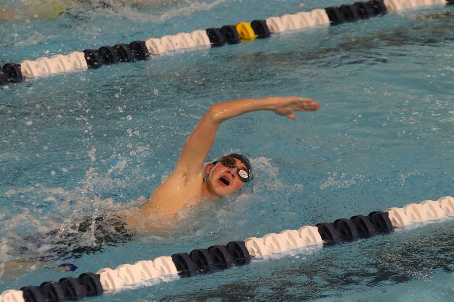 Taking a breath, freshman Andre Arnold competes in the 200-yard freestyle at the Shawnee Mission Aquatic Center Thursday, Dec. 9. 