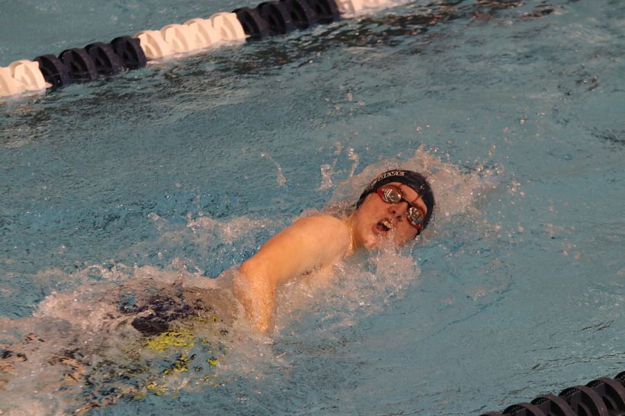 Cutting through the water, junior Derek Long swims the 100-yard freestyle. 
