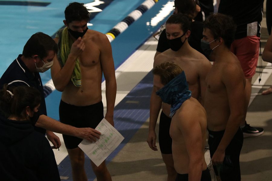 Speaking to the relay after their 200-yard freestyle relay, head coach Dan Dervin talks strategy with the boys. 