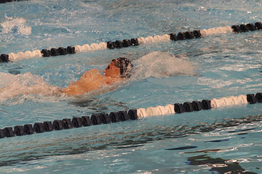 Competing in the 100-yard backstroke, junior Noah Collins swiftly swims past his competitors.