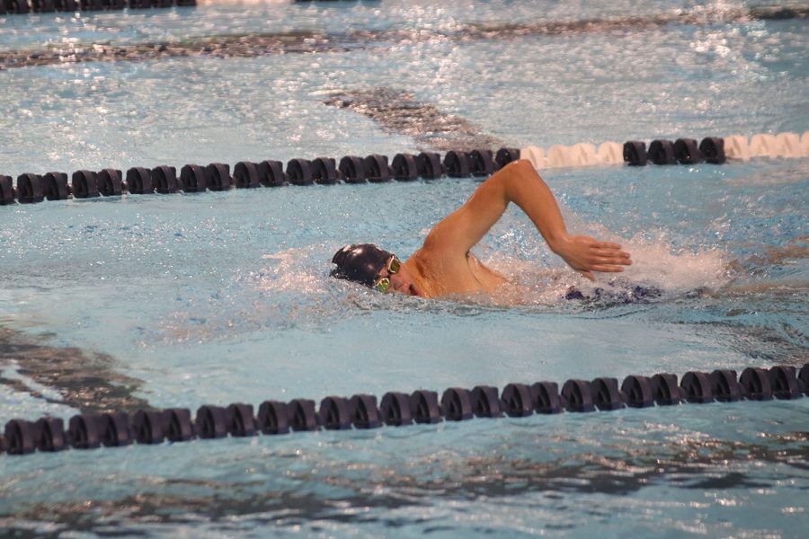 Slicing through the water, senior Cole McClure swims against his competitors in the 500-yard freestyle.