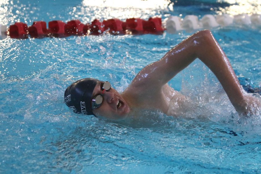 Mid-stroke, sophomore Dylan Miller takes a breath while swimming freestyle.

