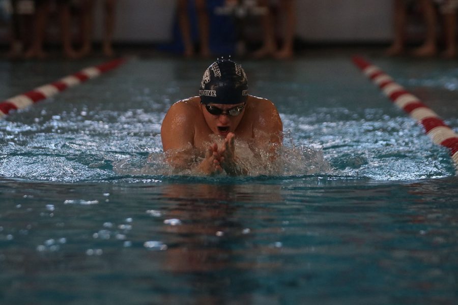 Above the water, senior Noah Collins continues swimming against his competitors.
