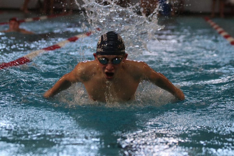 Coming up to breathe, freshman Andre Arnold continues swimming the butterfly.
