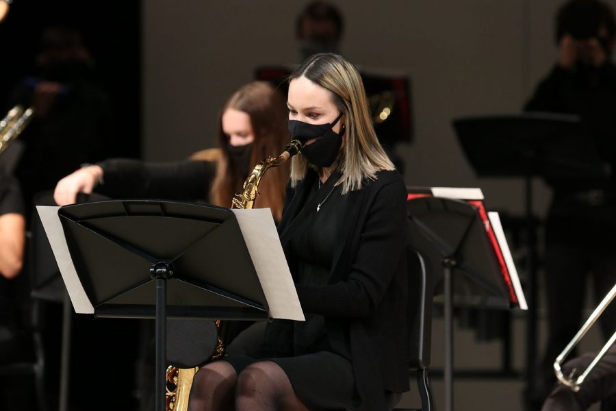 Eyes on her music, senior Ella Greenup continues playing her saxophone. The jazz band live streamed their first performance from the performing arts center over YouTube Wednesday, Dec. 9.