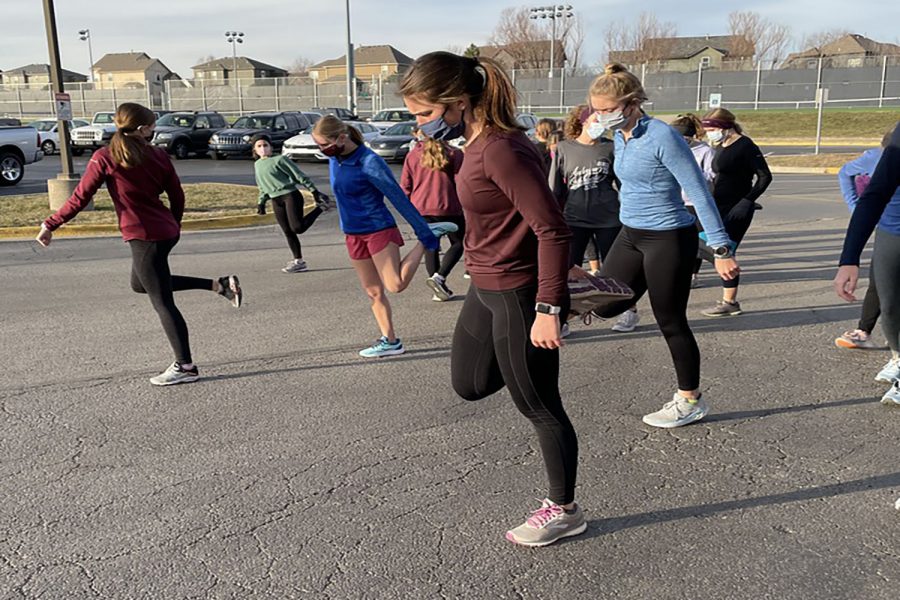 Stretching+and+warming+up+with+her+team%2C+senior+Logan+Pfeister+gets+ready+for+cross+country+winter+training+Monday+Dec.+15.+She%E2%80%99s+appreciative+of+being+able+to+train+during+winter+still%2C+%E2%80%9CThe+best+part+about+winter+training+is+I+feel+like+the+offseason+is+a+great+opportunity+to+get+better+for+the+cross+country+season%2C%E2%80%9D+Pfeister+said.+%E2%80%9CIt+is+also+fun+to+just+socialize+with+all+the+girls+and+not+have+the+stress+of+racing.%E2%80%9D+