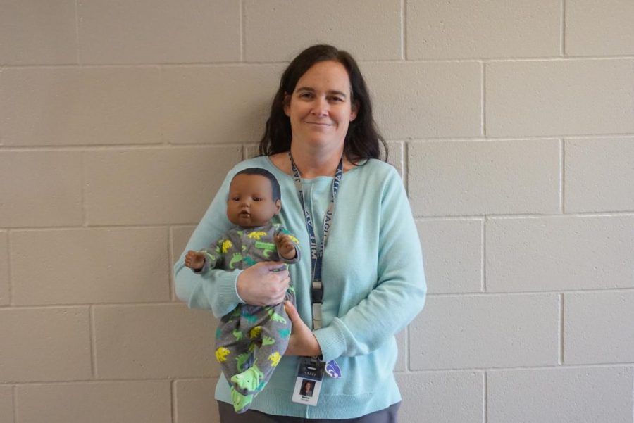 Teaching the class how to take care of their fake babies, Human Growth and Development teacher Ellen Gray shows off her baby via zoom on Dec. 4.