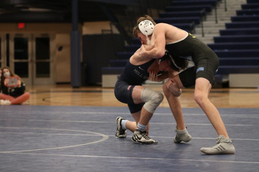 Pushing up against his opponent, freshman Maddox Casella attempts to know him off his feet.