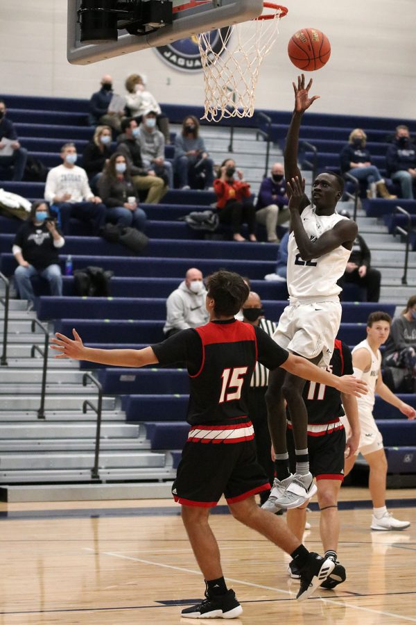 Jumping up in the air, sophomore Nen Matlock makes a two pointer in the first quarter of the game.