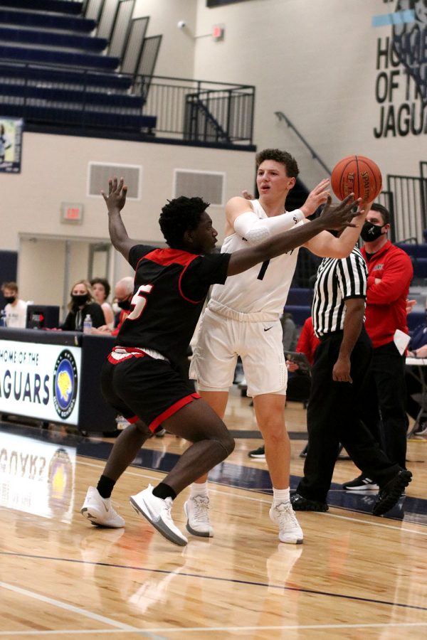 Looking for an open teammate, senior Nick Mason passes the ball while being guarded by the opposing team. 