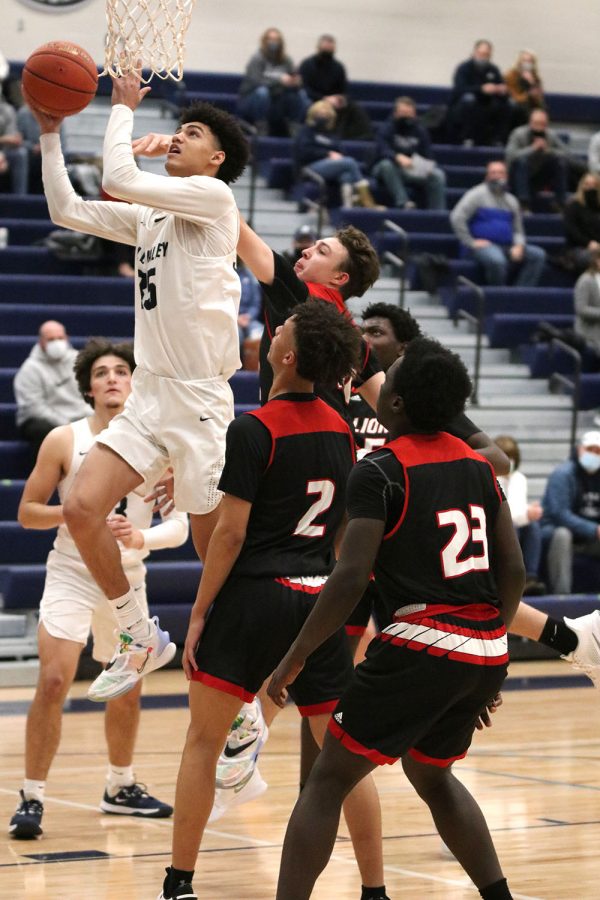 With his opponents behind him, junior Adrian Dimond makes a basket.