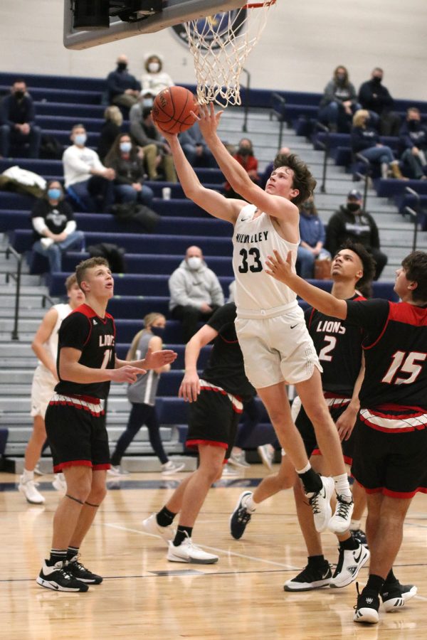 Reaching for the basket, sophomore Dylan Blazer scores two points before halftime.