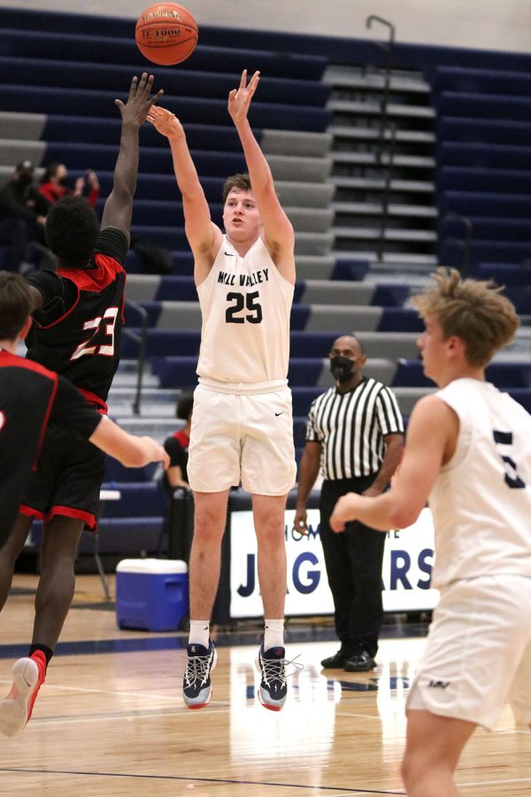 Behind the three point line, senior Aaron Kephart shots the ball to make a basket.