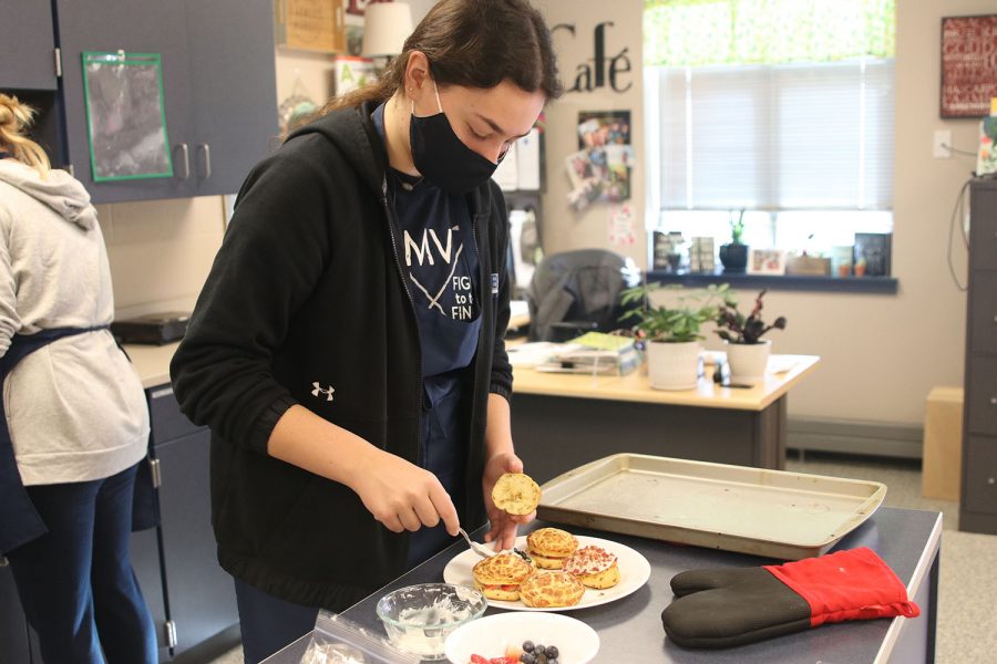 With cinnamon rolls, fruit and icing, senior Carlie Bradshaw finishes plating her dish.